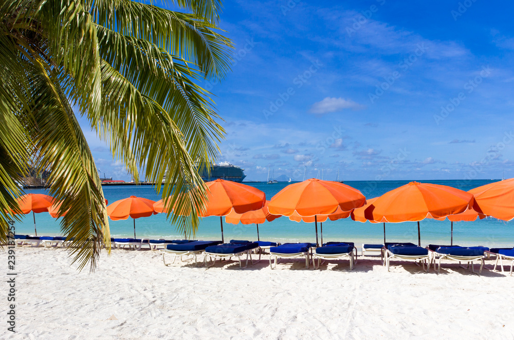  beach chairs and  red umbrellas on caribbean island St. Maarten