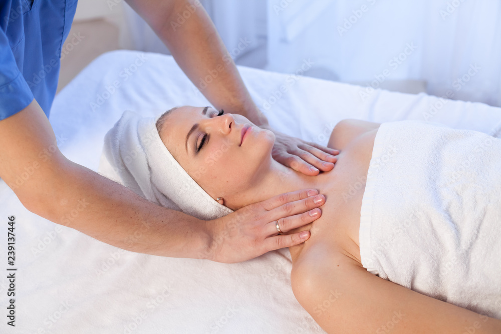 a massage therapist makes therapeutic massage of the face and neck in the Spa medicine