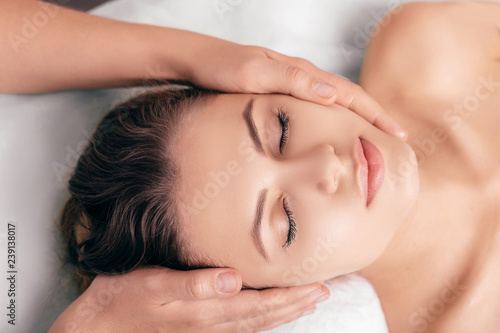 woman enjoying a relaxing head massage at spa salon