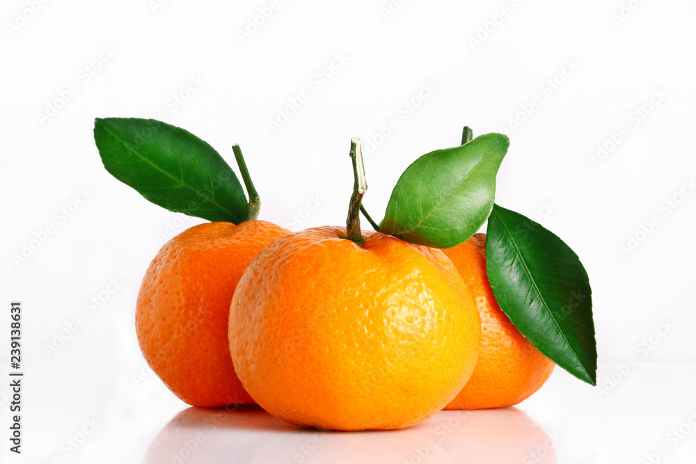 three tasty mandarin isolated. citrus tangerine or clementine with green leaves three tasty mandarin isolated. citrus tangerine or clementine with green leaves