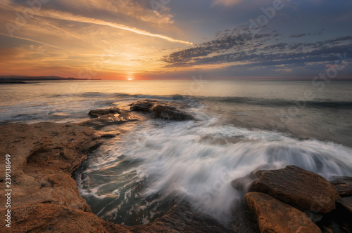 Seascape during sunrise. Beautiful natural seascape. Sea sunrise at the Black Sea coast. Magnificent sunrise with clouds and fire sun at the beginning of April.Ravda, Bulgaria © djevelekova