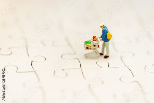 Miniatrue people: Shoppers with shopping cart. Tourism, shopping or business concept. photo