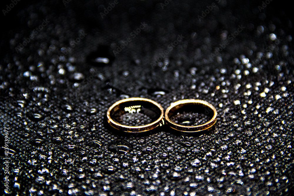 two wedding rings on a black background with water two wedding rings on a black background with water