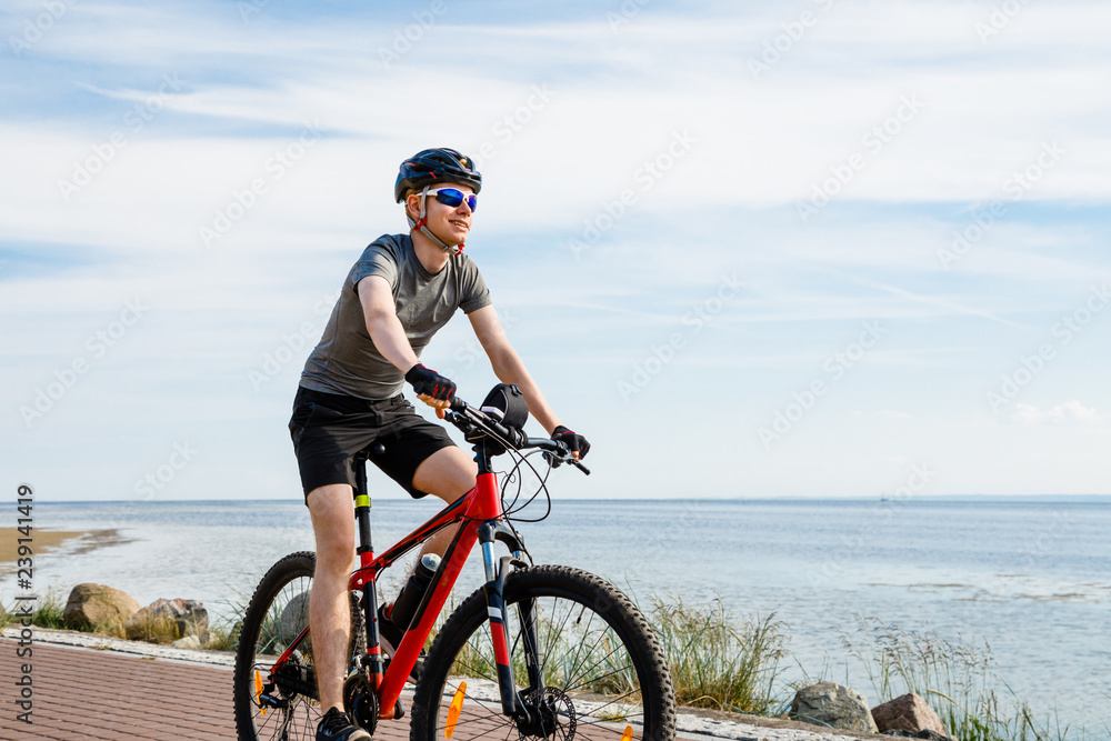 Fototapeta premium Young man biking at seaside