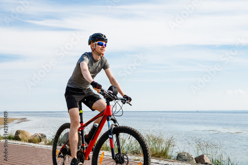 Young man biking at seaside