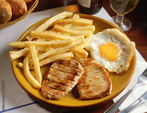 Plato combinado con dos trozos de lomo a la parrilla, un huevo frito y patatas fritas