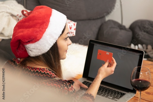lonely girl in a Christmas hat shopping online