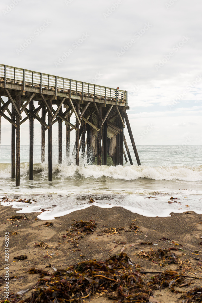 Waves breaking on the poles under the pier of San Simeon, California, USA Waves breaking on the poles under the pier of San Simeon, California, USA