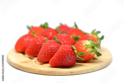 red strawberry on wooden plate