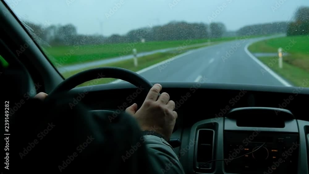 View from from inside, man driving in the rain on lonely highway View from from inside, man driving in the rain on lonely highway