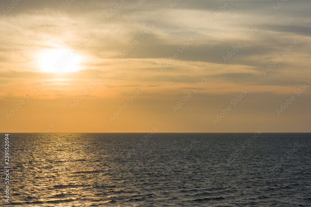 Bright gold solar path in the sea at sunset