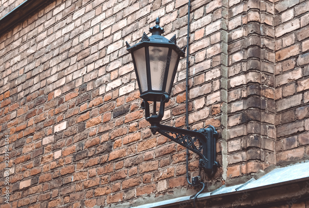 Wall lantern hanging on a roof of old house in the center of Riga, Latvia. October 25, 2018. Wall lantern hanging on a roof of old house in the center of Riga, Latvia. October 25, 2018.
