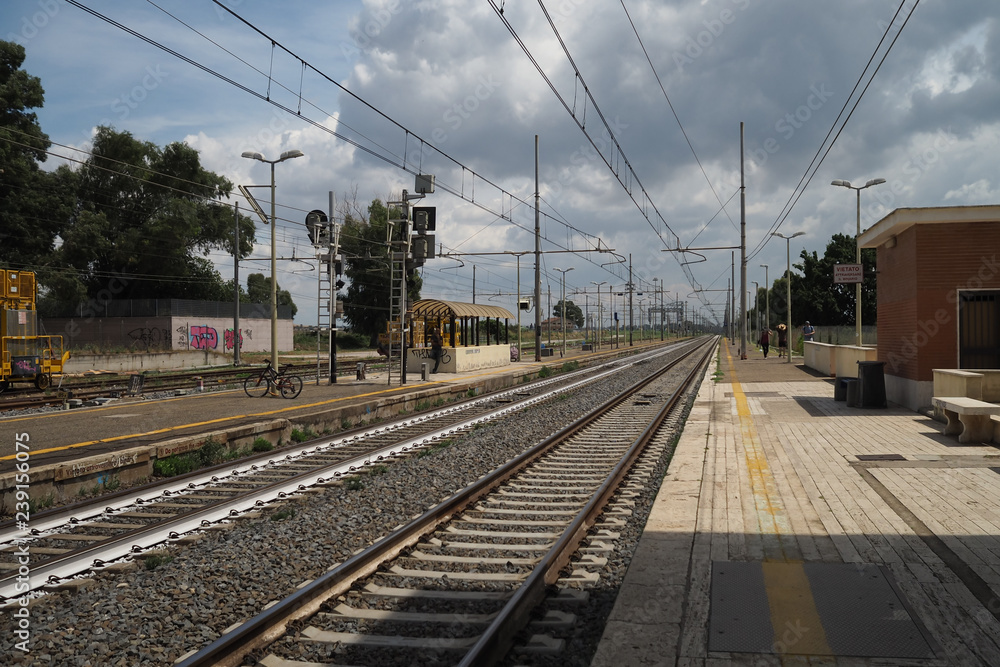 Hot day at Santa Severa train station, looking along the track with passengers waiting Hot day at Santa Severa train station, looking along the track with passengers waiting
