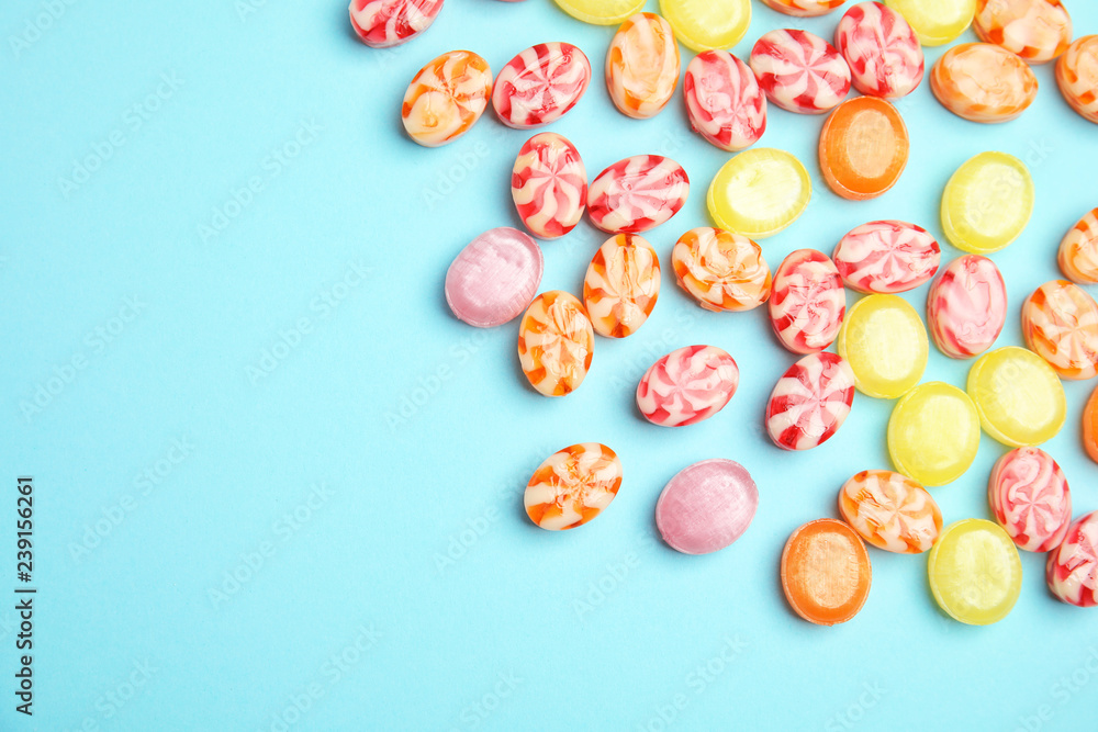 Flat lay composition with delicious colorful candies and space for text on color background