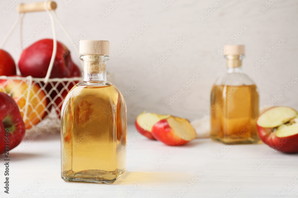 Composition with bottle of apple vinegar on table. Space for text Composition with bottle of apple vinegar on table. Space for text