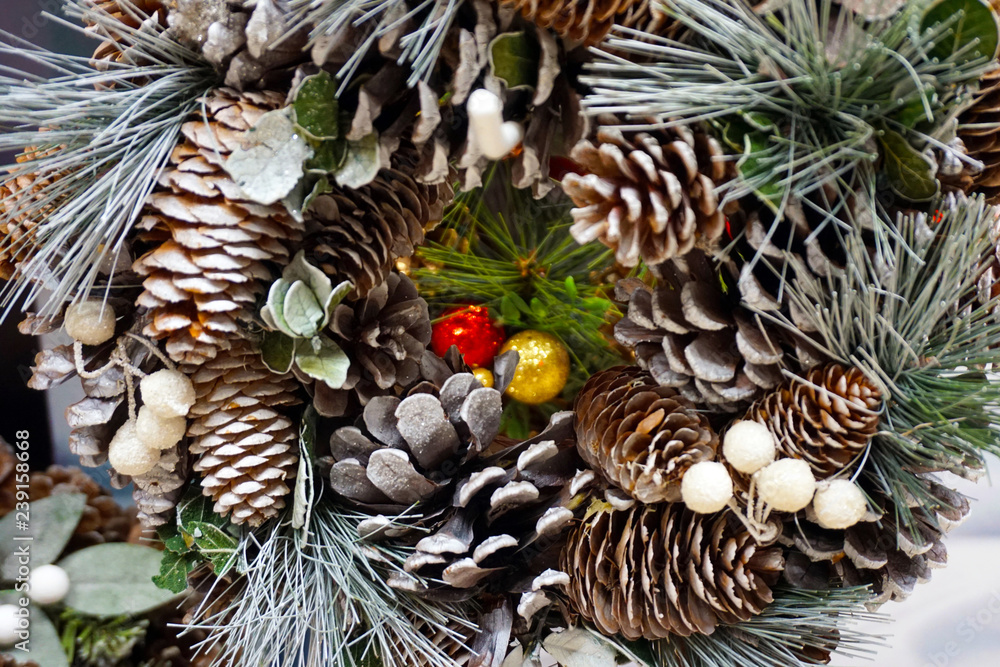 Obraz premium Christmas wreath from fir, pine and spruce twigs with cones, berries and snow as background - Image