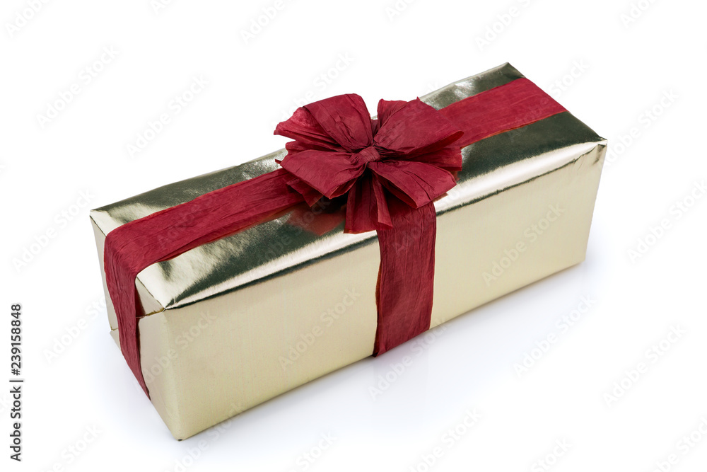 Gift box wrapped in gold wrapping paper, decorated with red raffia