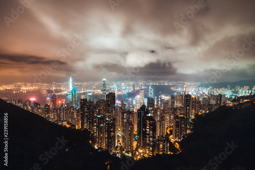 Beautiful Hong Kong island cityscape  aerial night view from Victoria Peak in cloudy storm weather. Asia tourism  business financial district  tourist attraction  or Asian travel destination concept