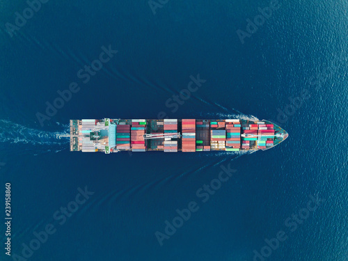 Aerial top view container ship on the sea full speed transport container for logistics import export or shipping background.