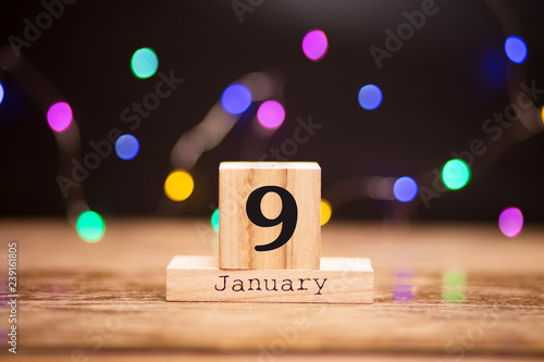Wallpaper Mural January 9th. Day 9 of January set on wooden calendar on dark background with garland bokeh. Winter time. Holiday Composition Torontodigital.ca