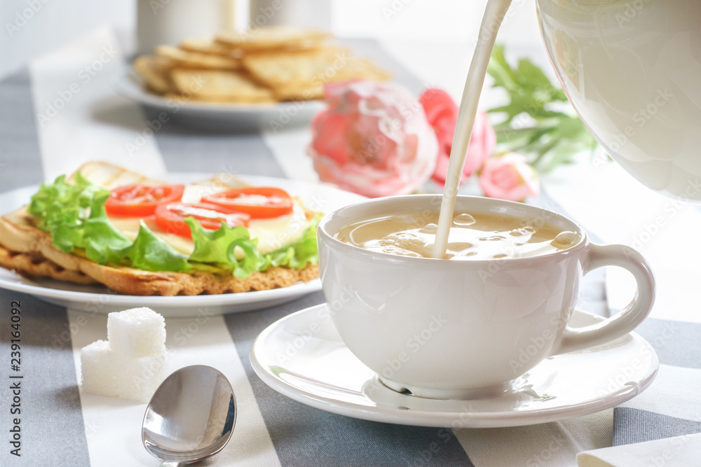Fresh, tasty breakfast with a sandwich and tea on a light background. Fresh, tasty breakfast with a sandwich and tea on a light background.