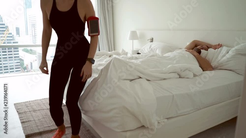 Young sporty woman going for run, while her boyfriend sleep, 4K
