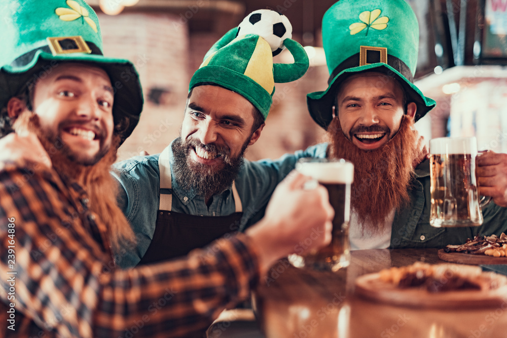 Cheerful men celebrating football championship and Saint Patrick Day in pub