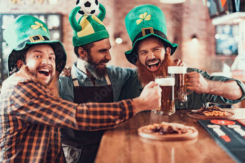 Εκτύπωση καμβά Cheerful friends celebrating football championship and Saint Patrick Day in pub