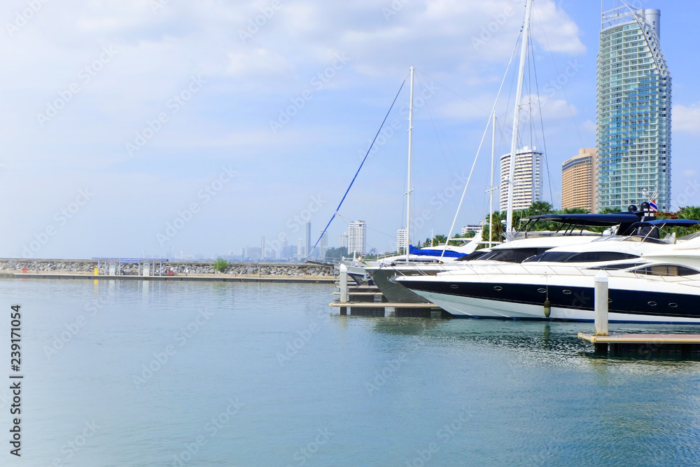 Fototapeta premium Yacht lie up in the port on seaside with blue sky, boat on the coast line, View on the sea shore, Yacht park on riverside, Bright clouds sky on sea in Thailand