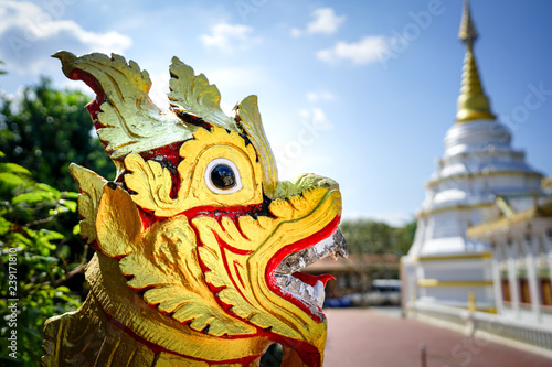 Asia gold red lion statue with temple background.