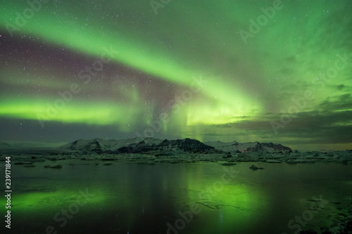 Northern Lights over frozen glacier lake and mountains in Iceland winter © sue
