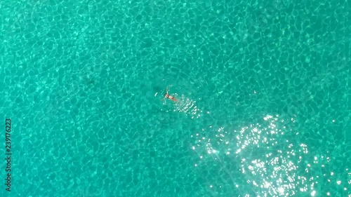 Aerial view of a woman swimming in the sea of Atokos island, Greece photo