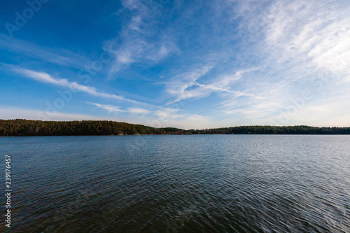 blue sky white clouds over calm body of water