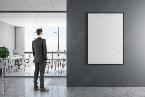 Businessman in modern office with poster