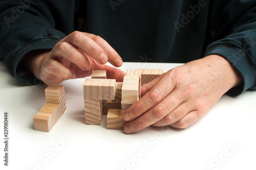 closeup of man hand with wooden puzzle  on white table background
