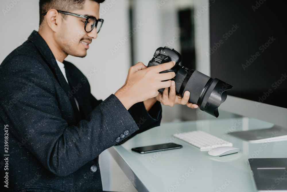 Cheerful asian reporter working in office on laptop Cheerful asian reporter working in office on laptop