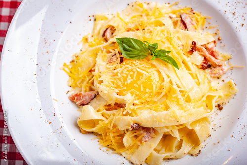 Italian cuisine. Pasta carbonara with bacon, cheese and egg on white plate. Close up