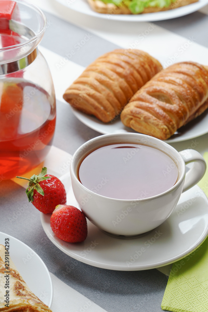 Fresh, tasty breakfast with tea and buns on a light background. Fresh, tasty breakfast with tea and buns on a light background.