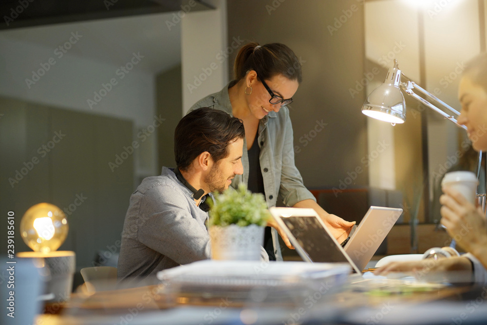 Business partners going over project in co working space Business partners going over project in co working space