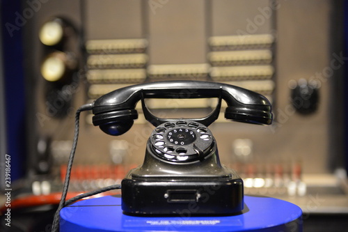Antique 1930`s black phone on blue table 
