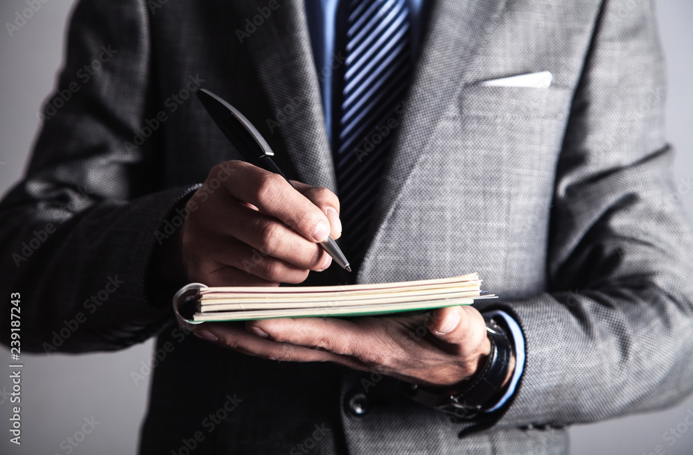 Businessman writing on notepad. Business concept Businessman writing on notepad. Business concept