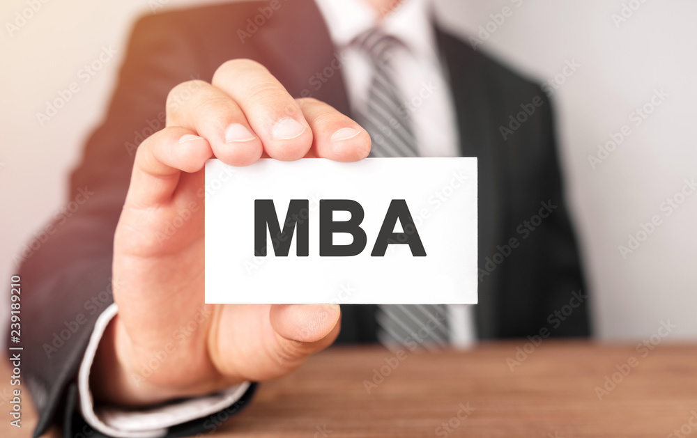Businessman holding a card with text MBA Businessman holding a card with text MBA