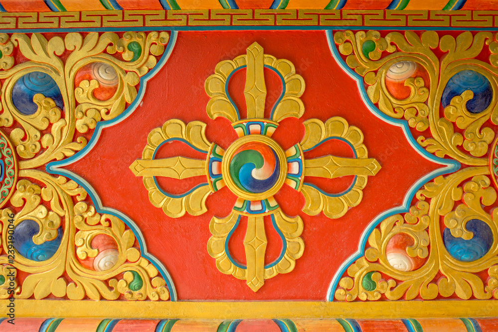 a colorful bright red yellow blue Buddhist vajra image on the wall of the temple. sacred images