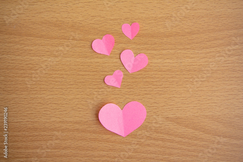 Pink paper cut of mini heart on brown background,love valentine concept, minimal flat lay.