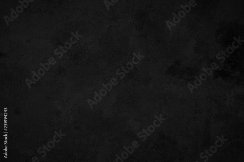 Close-up of a weathered and aged dark gray, almost black, concrete wall, texture background.