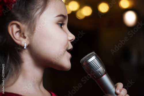 The girl with the microphone. A small child sings karaoke closeup