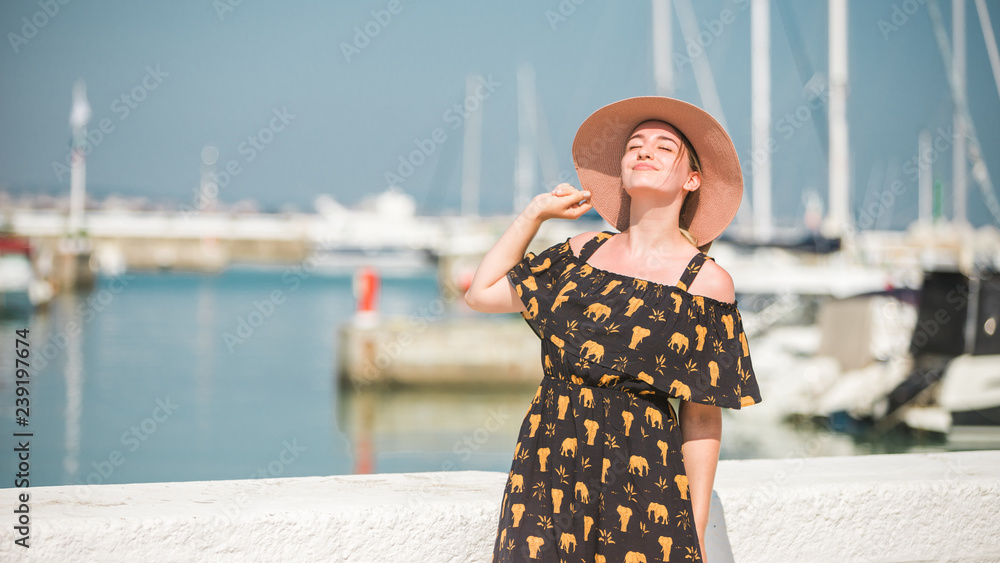 Fashionable photo: A sensual woman in a long red dress poses in the sea  next to old wooden piles. Stock Photo by ©DetkovDmitrii 391463284