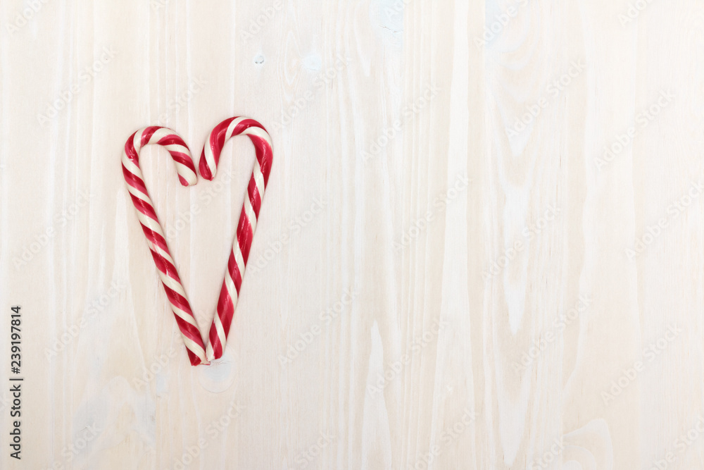 Valentine's Day. The composition of the heart of the Christmas candy on a light wooden background with texture. Top view