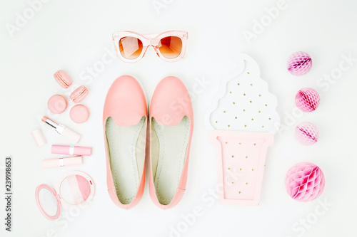 Flat lay of female fashion accessories, shoes, makeup products on pastel color background. Beauty and fashion concept