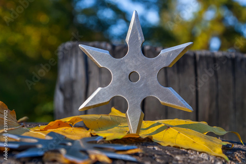 Shuriken (throwing star), traditional japanese ninja cold weapon stuck in wooden background